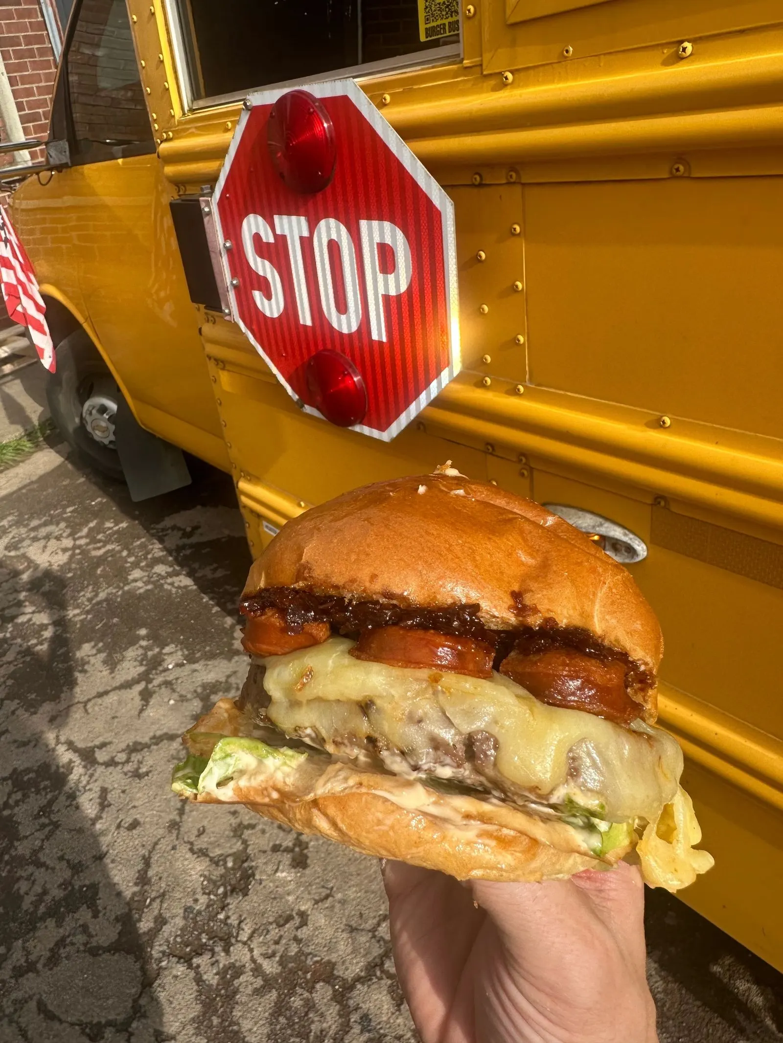 Beef and chorizo burger in front of the bus stop sign