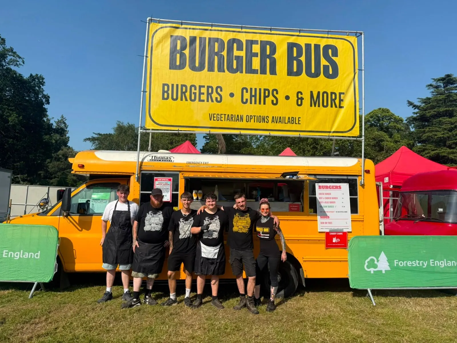 The Burger Bus team in front of the bus at a festival