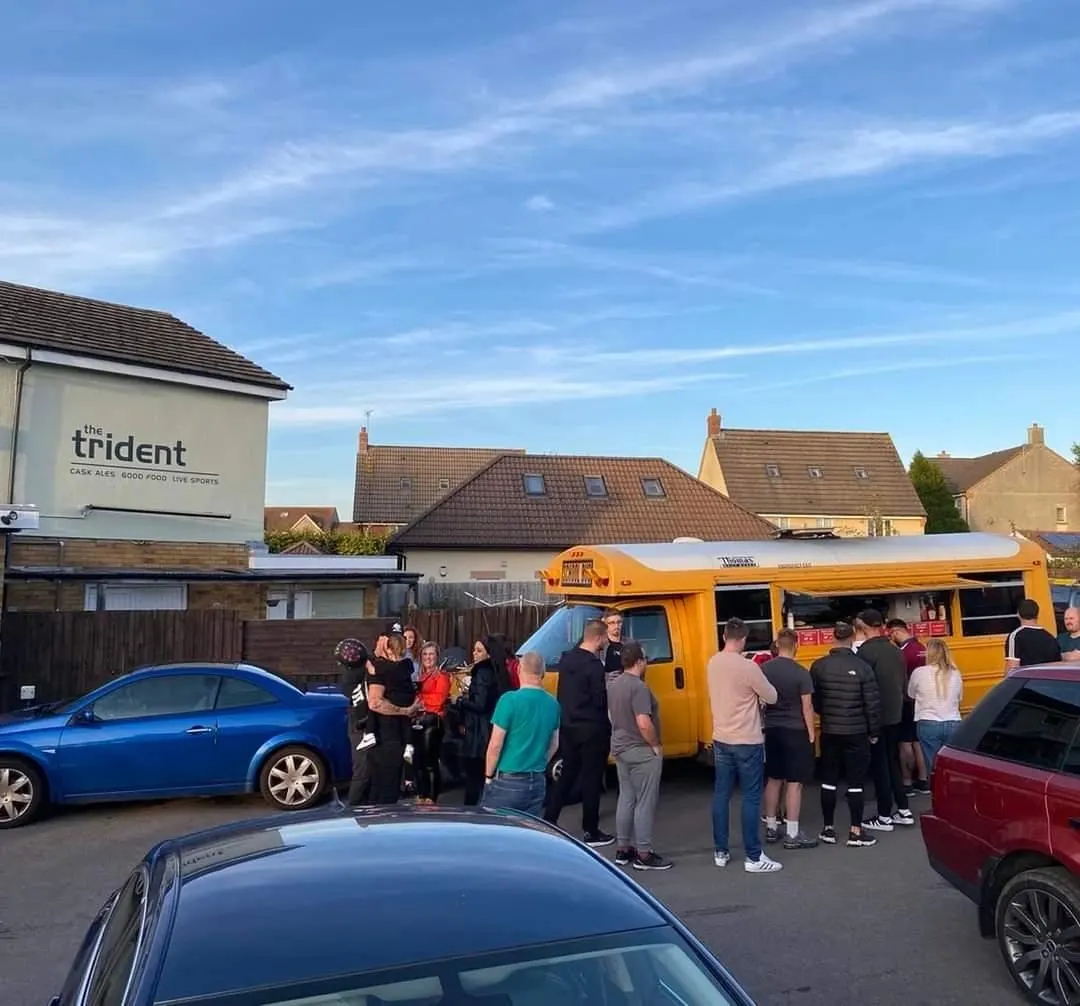 Customers queuing at Burger Bus in a pub car park in Bristol