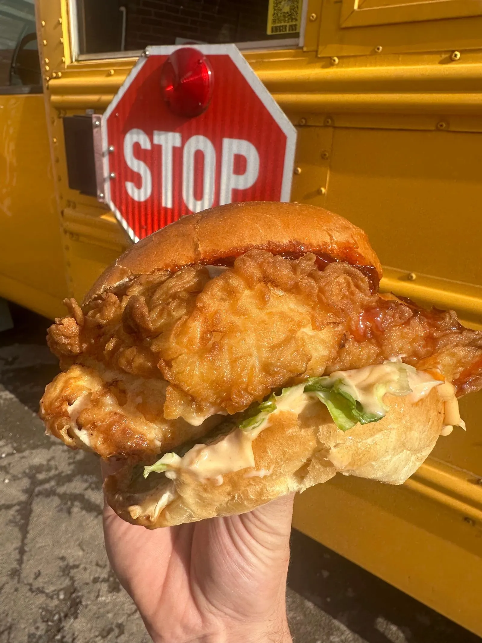 Fried chicken burger in front of the bus stop sign